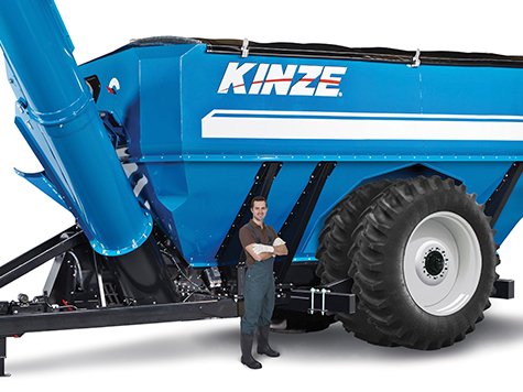 Large blue KINZE grain cart with a person standing beside it for scale